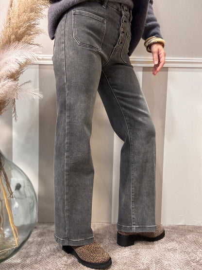 Le jeans délavé à boutons brodés