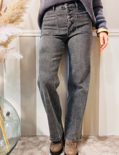 Le jeans délavé à boutons brodés