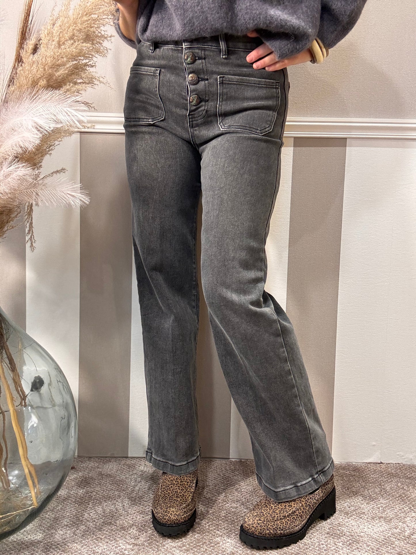 Le jeans délavé à boutons brodés